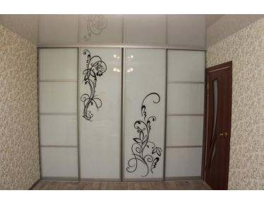 Белый глянцевый шкаф-купе с рисунком, встроенный в нишу комнаты