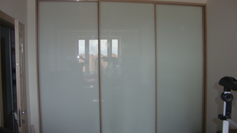 Шкаф-купе встроенный в нишу комнаты с белыми стёклами
